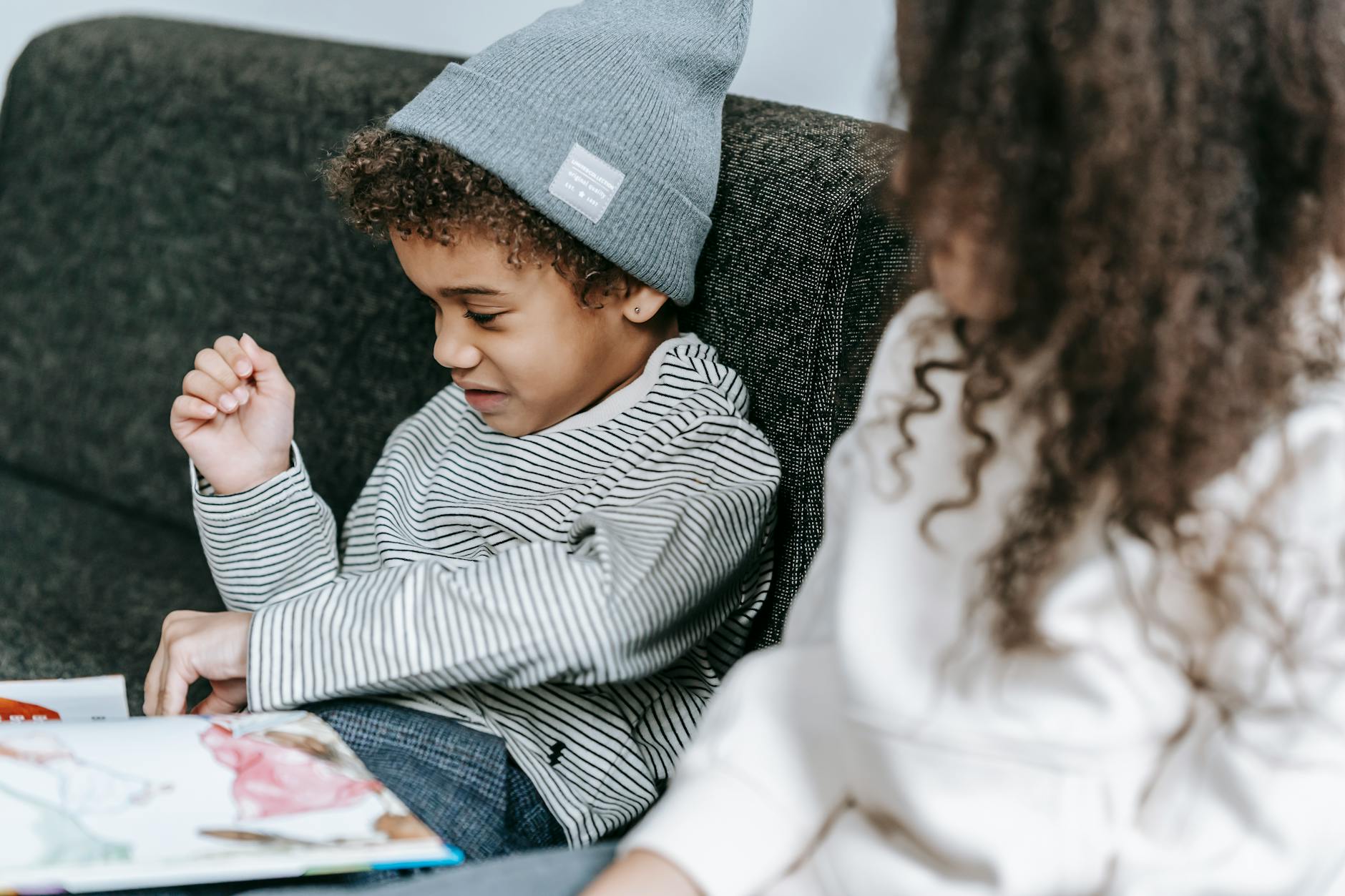 curious smart black boy reading fairytale while sister listening