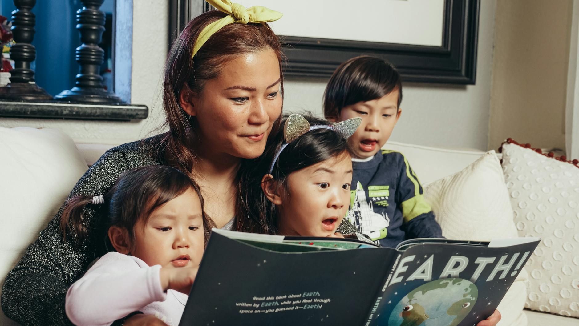 woman reading a book with her kids