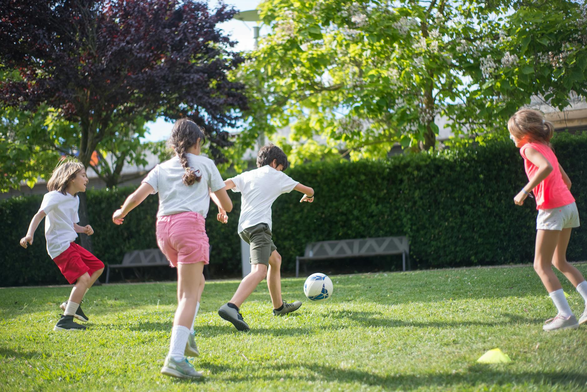 young kids playing football on the field